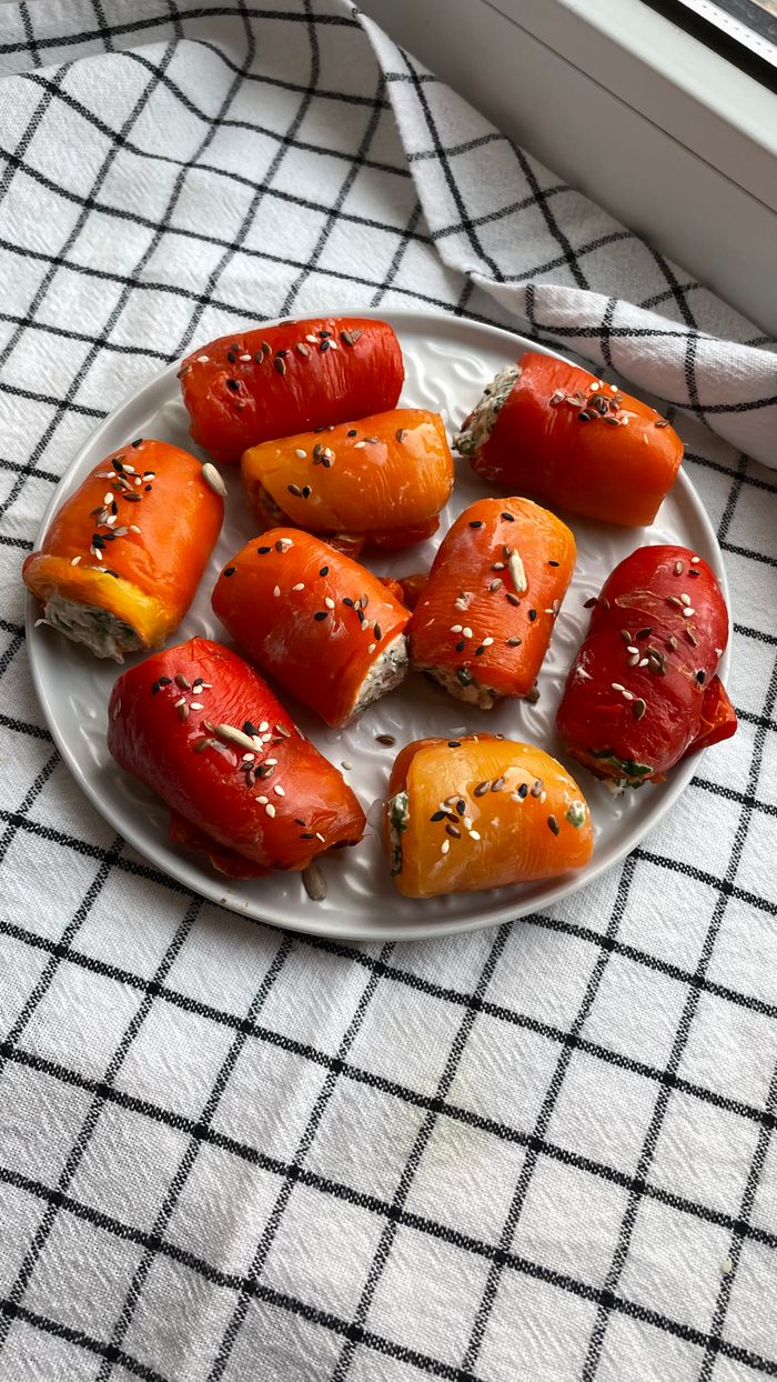 Home Colorful stuffed bell peppers garnished with seeds on a plate.