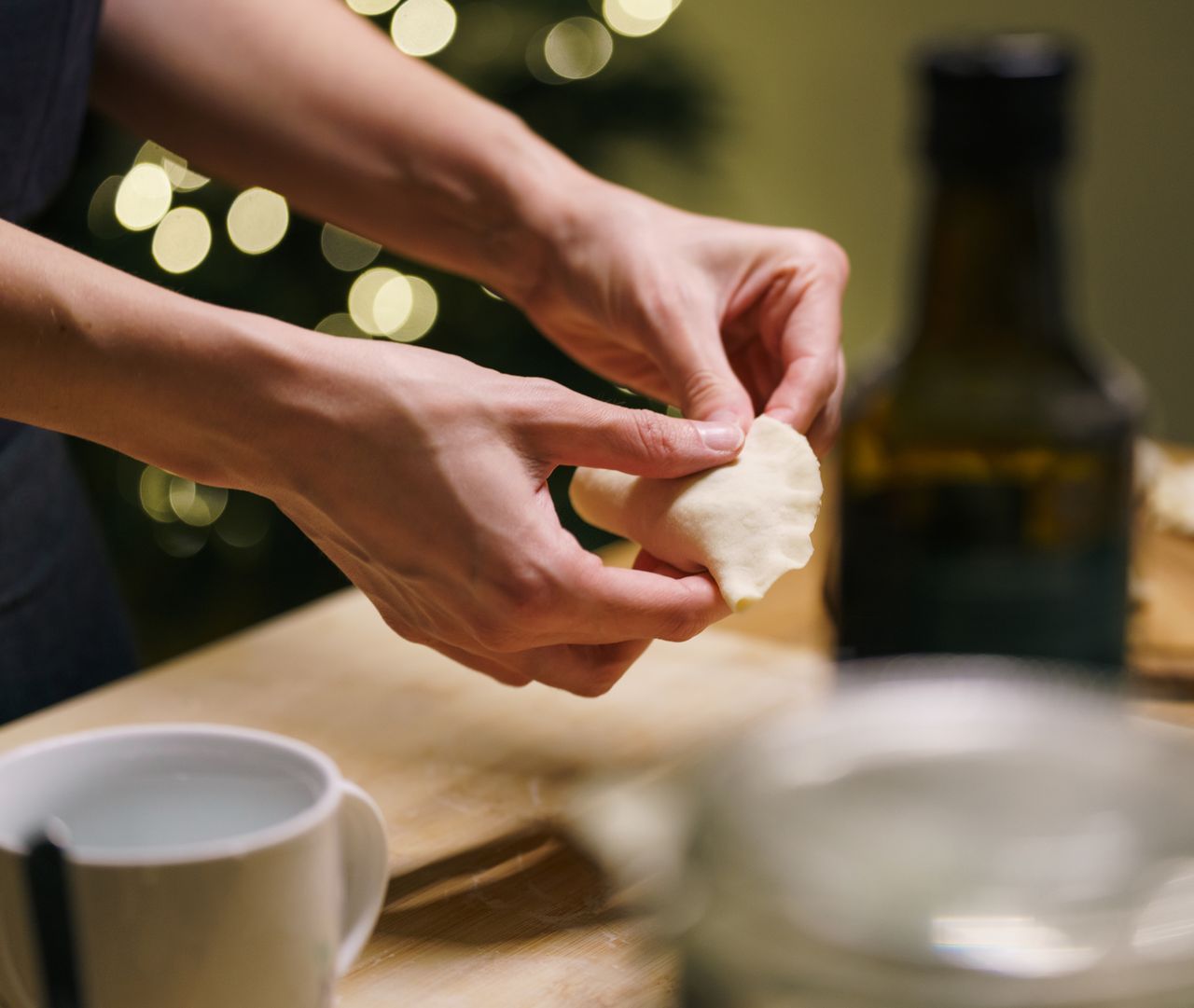 The Art of Drawing Readers In: Your attractive post title goes here Hands crafting dumplings in a cozy kitchen setting with warm festive lights. Perfect for holiday cuisine.