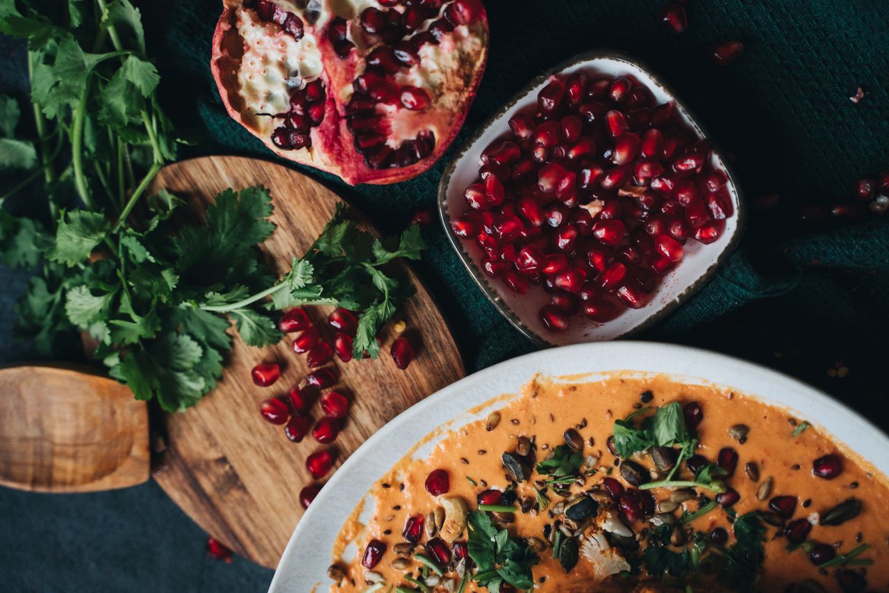 Services Delicious vegan dish garnished with pomegranate and fresh cilantro, perfect for fall dining.